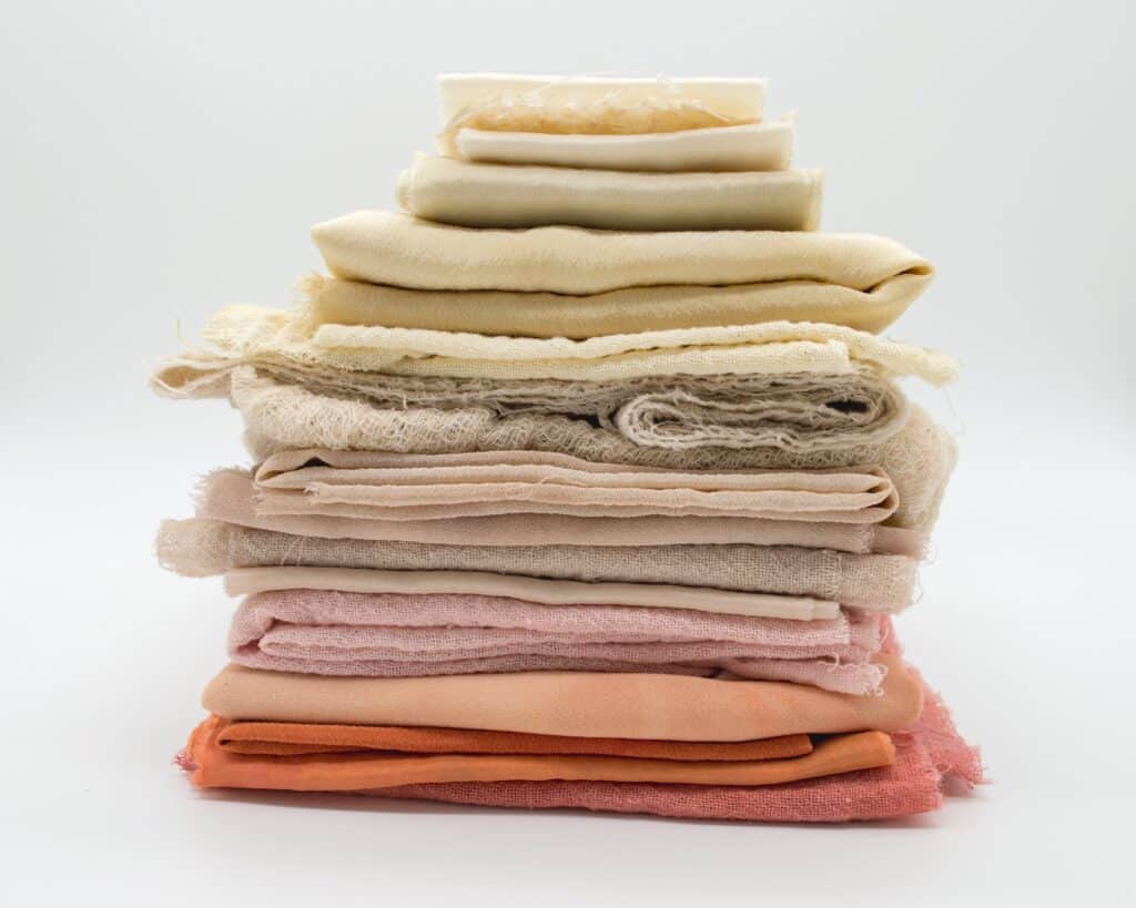 pile of sustainable fabrics, destined for hemp clothing. In pinks to yellows